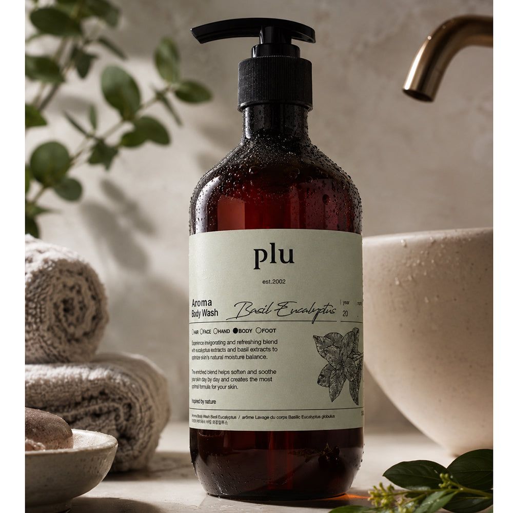 PLU Bagnoschiuma Aroma Basilico & Eucalipto accanto a asciugamani e una ciotola.