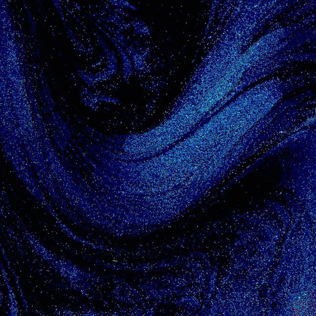 Primo piano astratto di glitter blu su sfondo scuro.