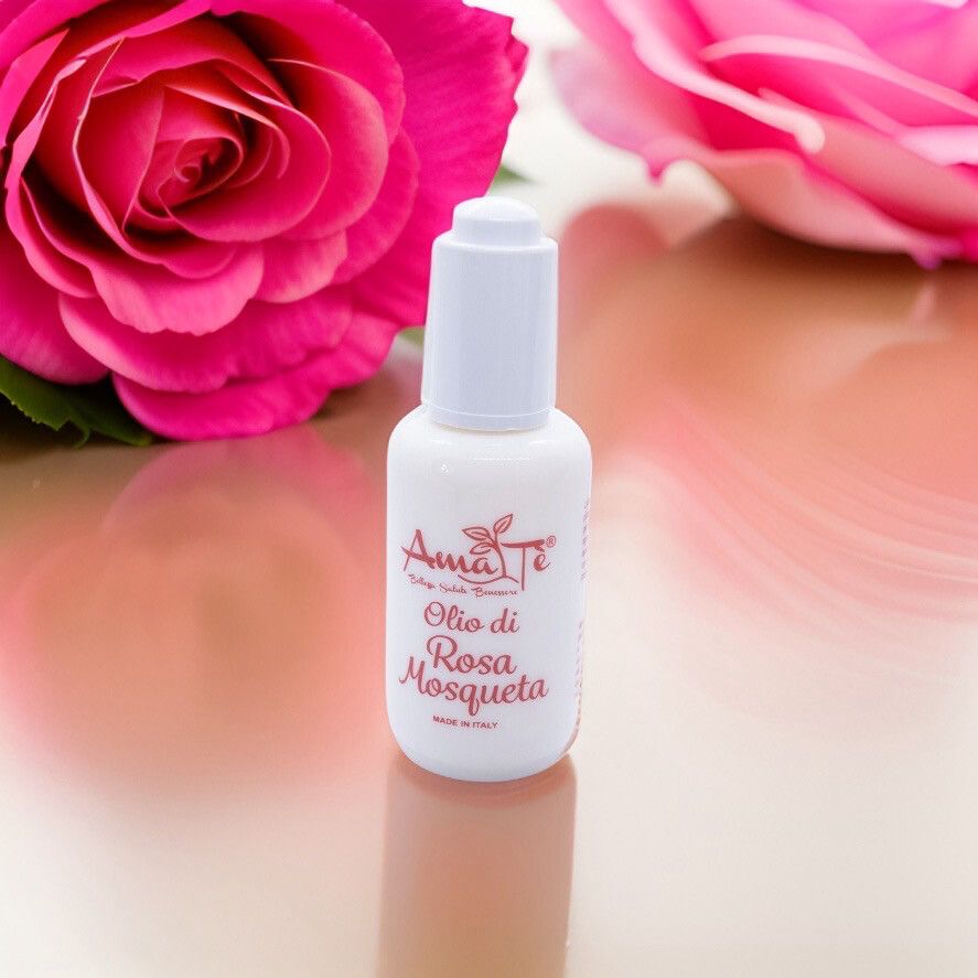 Flacone bianco con scritta rossa: Amatè Olio di Rosa Mosqueta. Made in Italy. Con rose sullo sfondo.