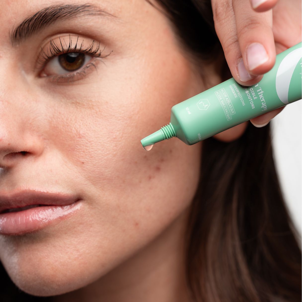 Tubo verde, goccia. Applicazione sulla pelle. Testo: Skin Therapy, Cure & Routine.