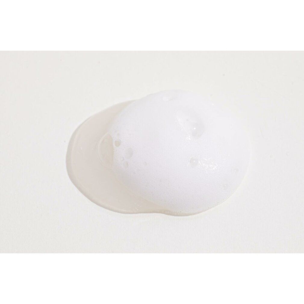 Schiuma bianca su sfondo chiaro. Primo piano, consistenza visibile.