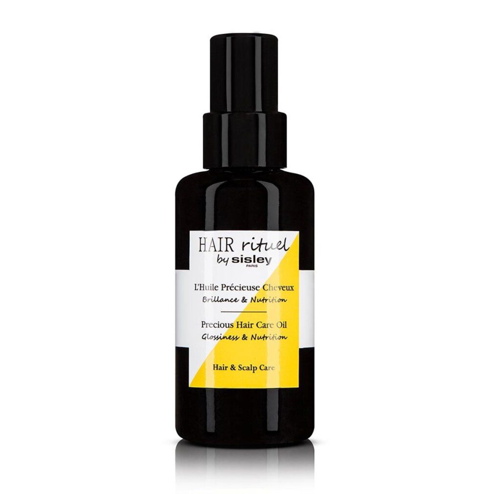 Flacone nero con etichetta gialla. Scritta: Hair Rituel by Sisley, L'Huile Précieuse Cheveux, Precious Hair Care Oil.