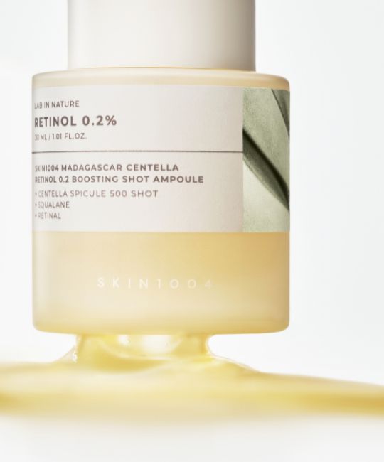 Flacone di vetro con pipetta. Scritta: Retinolo 0,2%. Nome prodotto: SKIN1004 Madagascar Centella Retinol 0.2 Boosting Shot Ampoule. Liquido che cola.