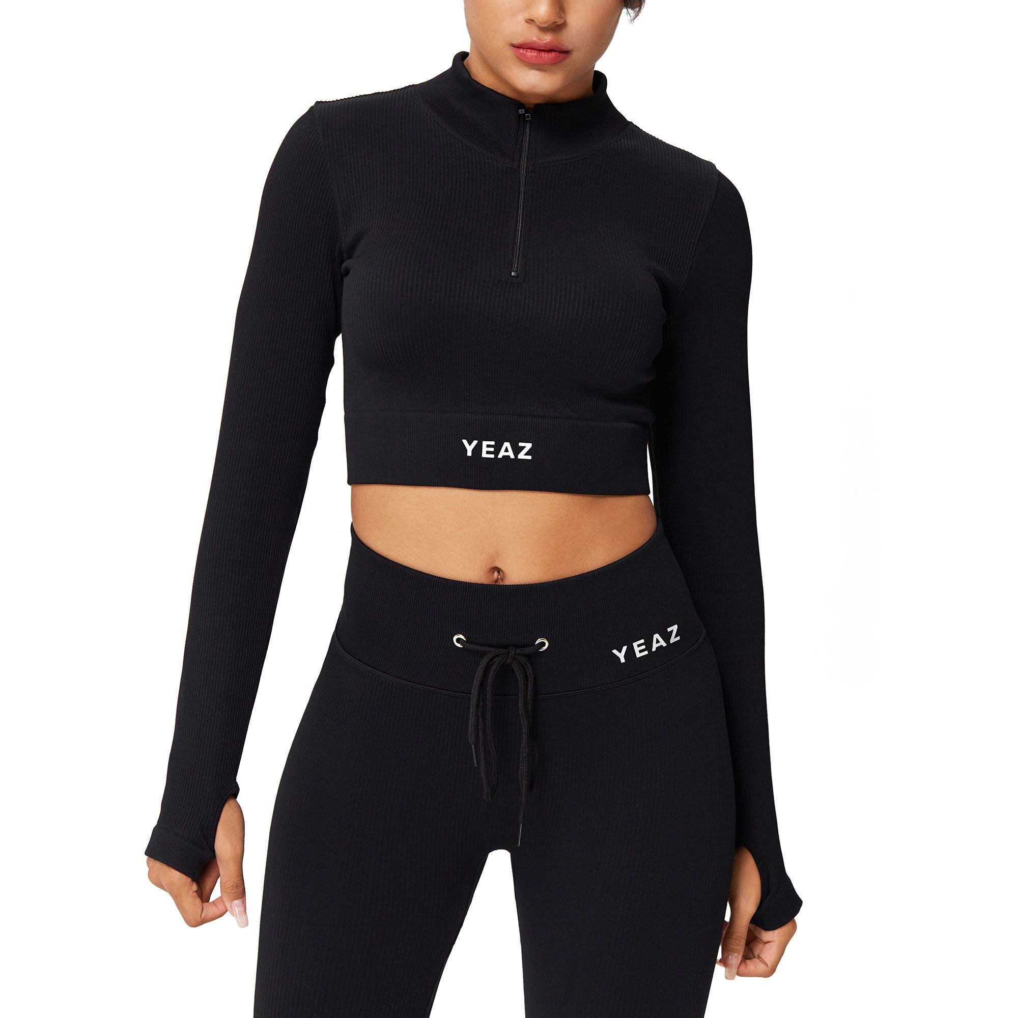 Top corto nero a maniche lunghe con zip e fori per i pollici. Logo "YEAZ" sulla fascia in vita.
