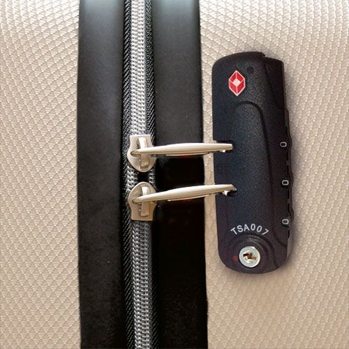 Primo piano di una serratura TSA nera con simbolo a diamante rosso. Combinazione numerica e foro chiave.