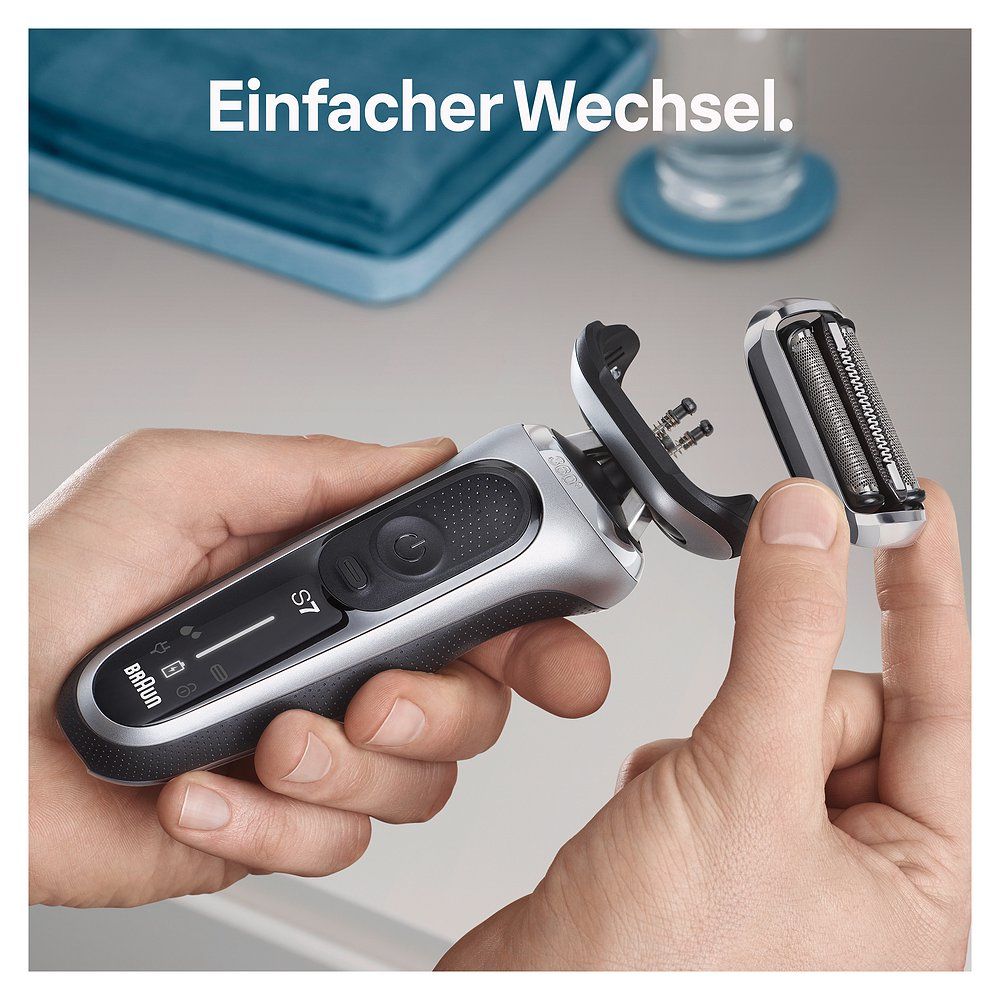 Mani cambiano la testina di un rasoio Braun Series 7. "Einfacher Wechsel" è visibile in tedesco.