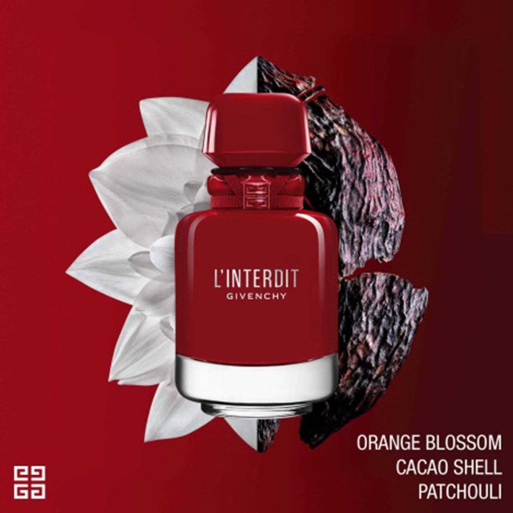 Flacone rosso Givenchy L'Interdit Rouge Ultime. Flacone con anello argentato e tappo rosso. Sfondo con fiori e buccia di cacao.