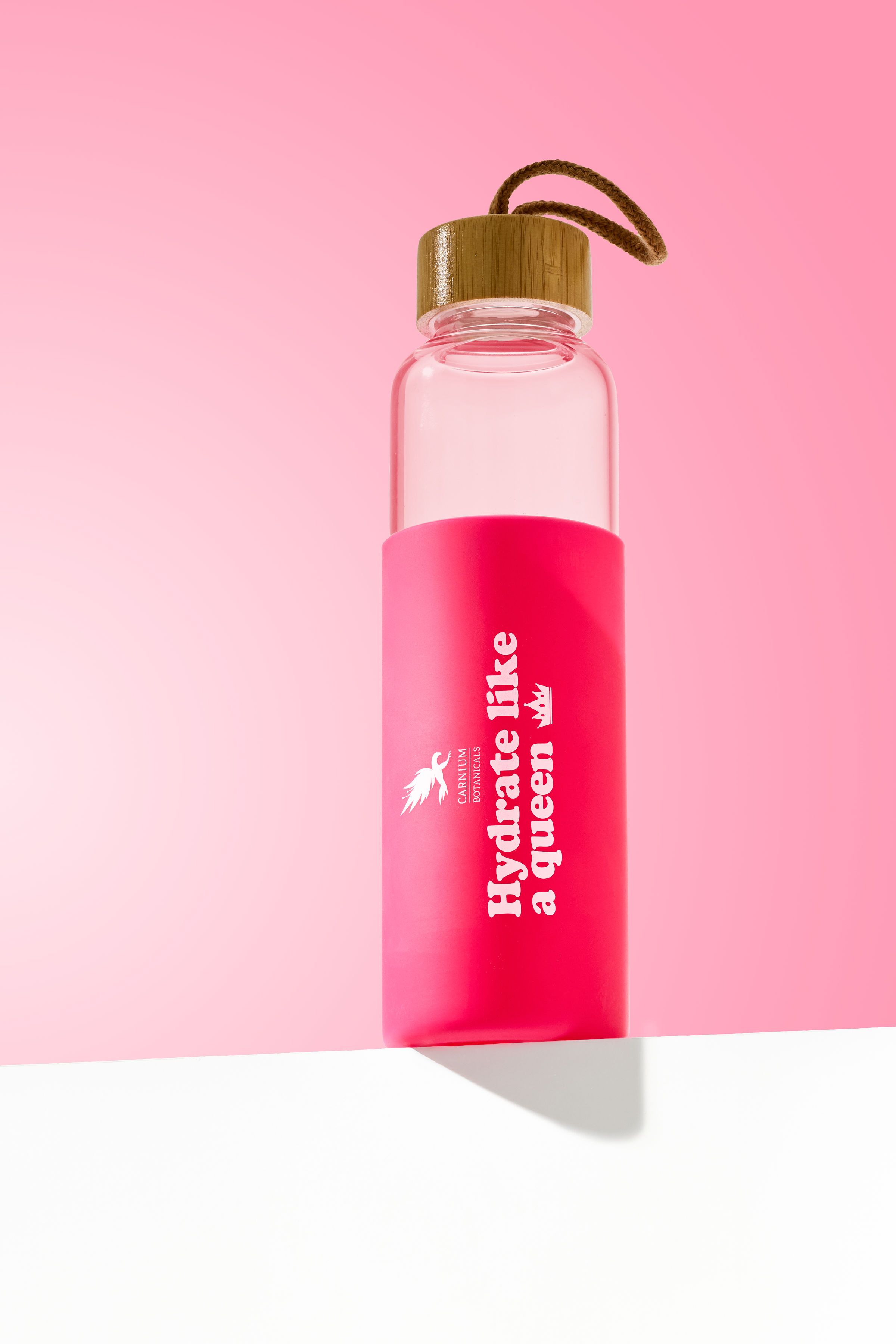 Borraccia con rivestimento rosa e scritta. Tappo in bambù con anello. Scritta: Hydrate like a queen.