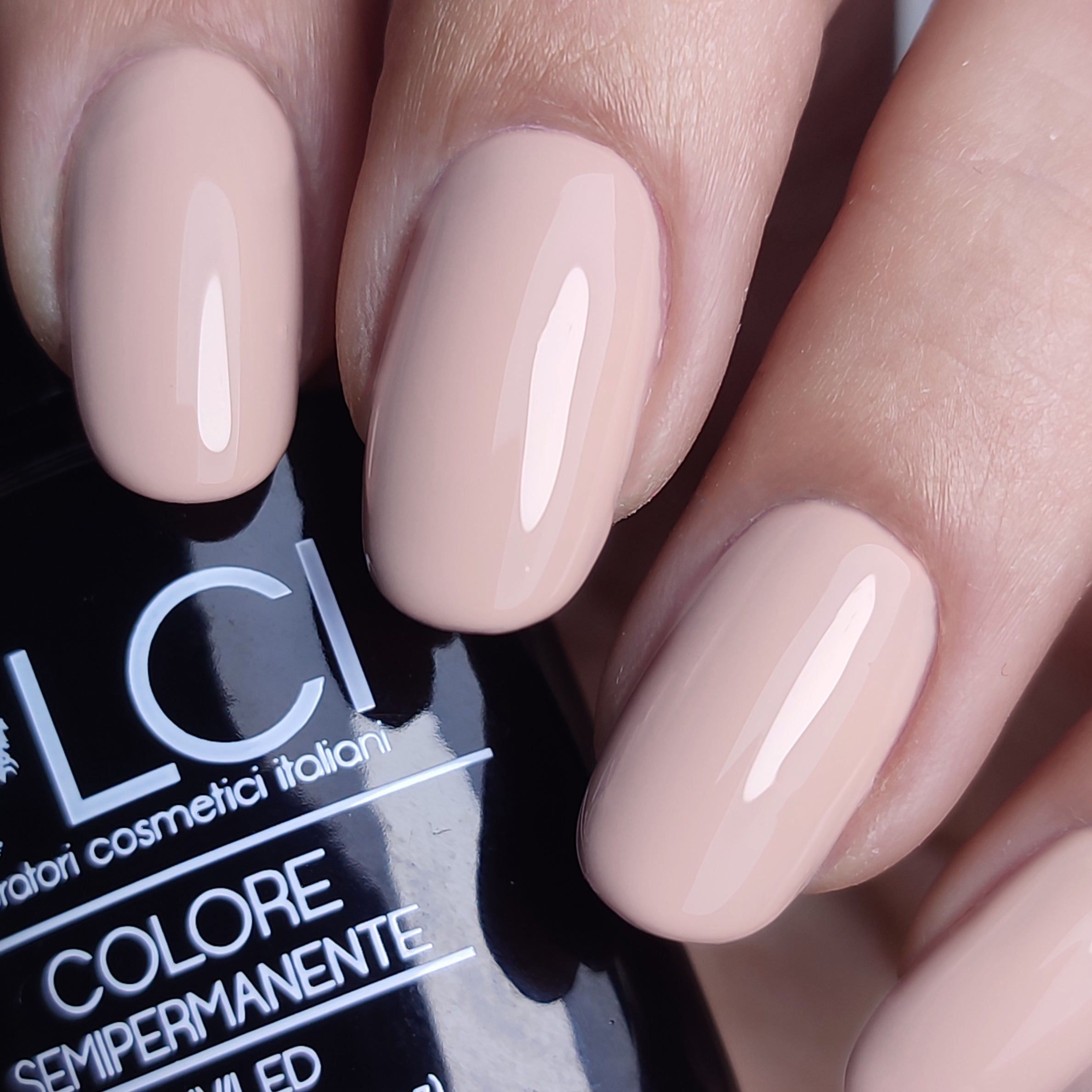 Mano con unghie smaltate nude. Scritta: LCI, Colore Semipermanente.