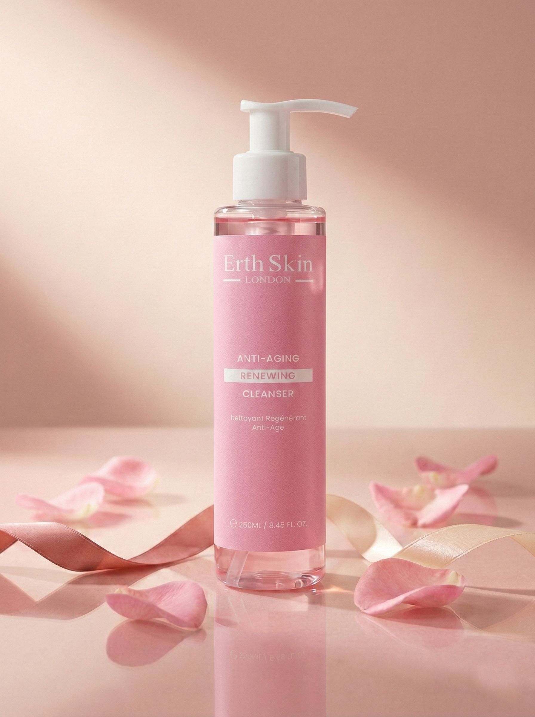 Flacone rosa con dosatore bianco. Scritta: Erth Skin London, Anti-Aging Renewing Cleanser. Decorazione con petali e nastri.