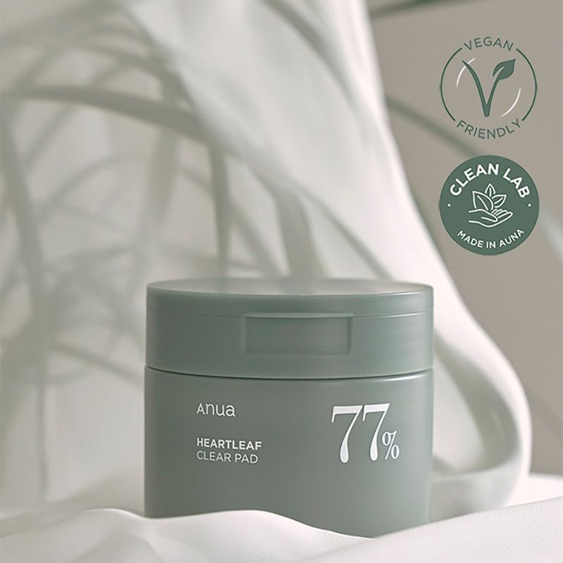Barattolo verde con coperchio. Scritta: Anua, HEARTLEAF CLEAR PAD, 77%. Sigilli Vegan e Clean Lab.