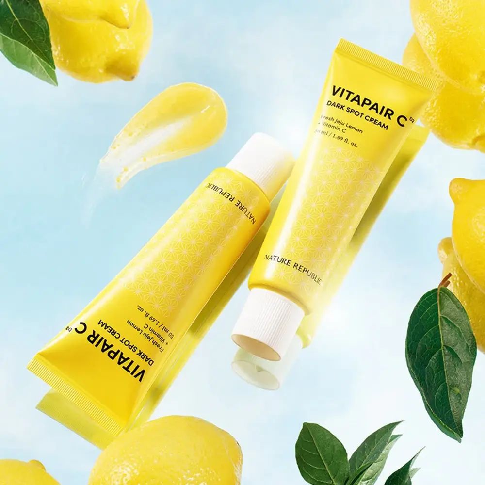 Due tubi gialli con tappi bianchi. Scritta: Vitapair C Dark Spot Cream. Limoni e foglie sullo sfondo.