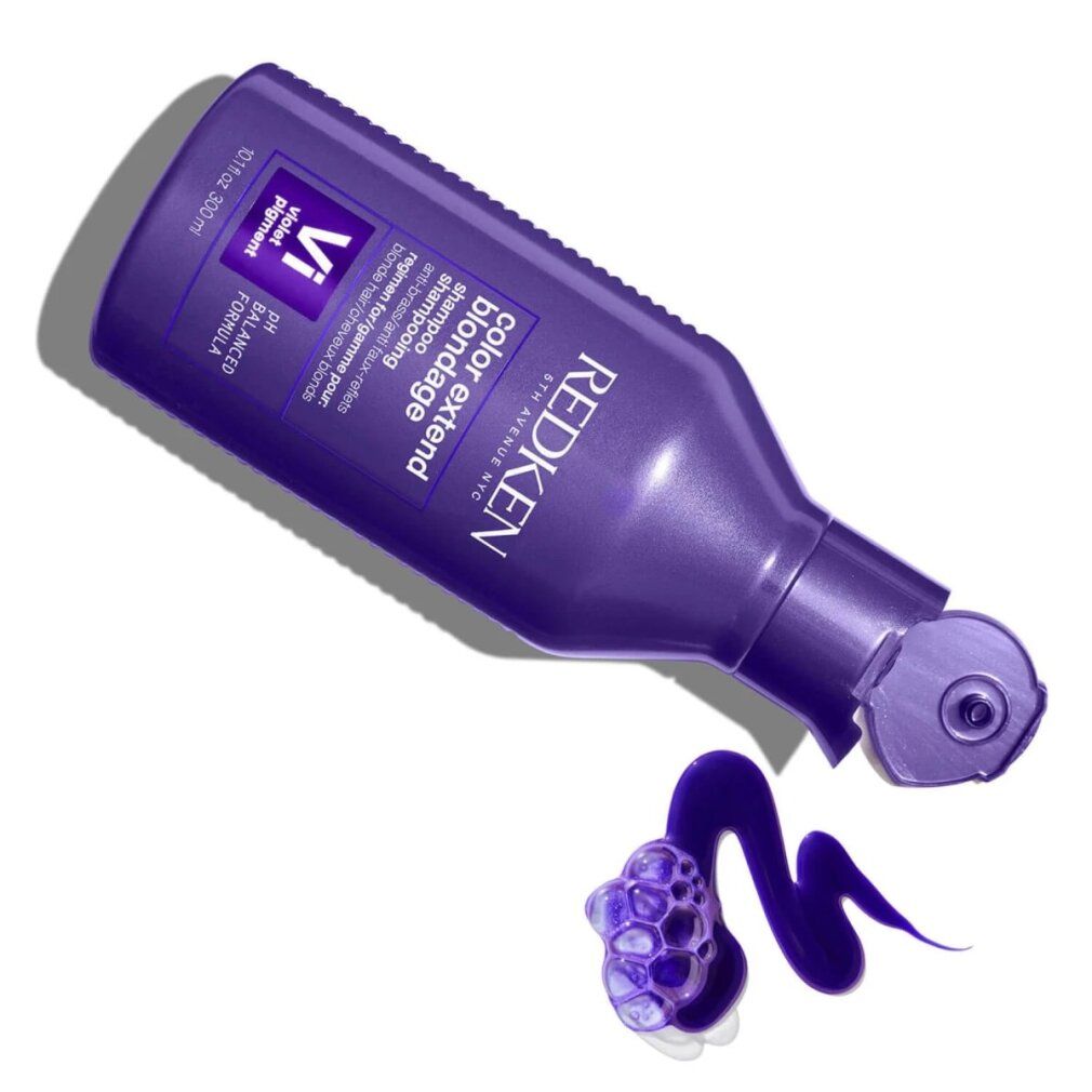 Flacone di shampoo viola Redken. Nome del prodotto e informazioni. Liquido che fuoriesce.