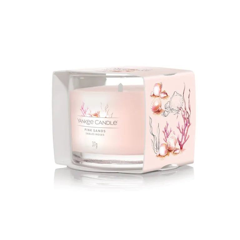 Candela in confezione. Cera rosa, vetro. Scritte: Yankee Candle, Pink Sands, Sables Roses, 37g. Confezione con decoro conchiglie.