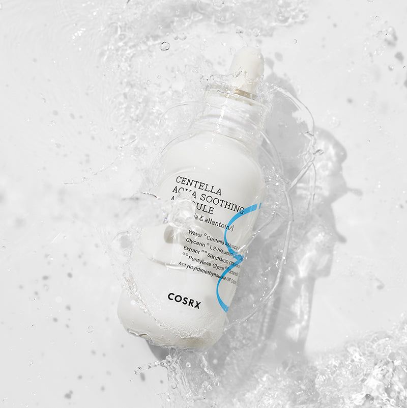 Flacone bianco con contagocce circondato dall'acqua. Scritta: Centella Aqua Soothing Ampoule, COSRX.