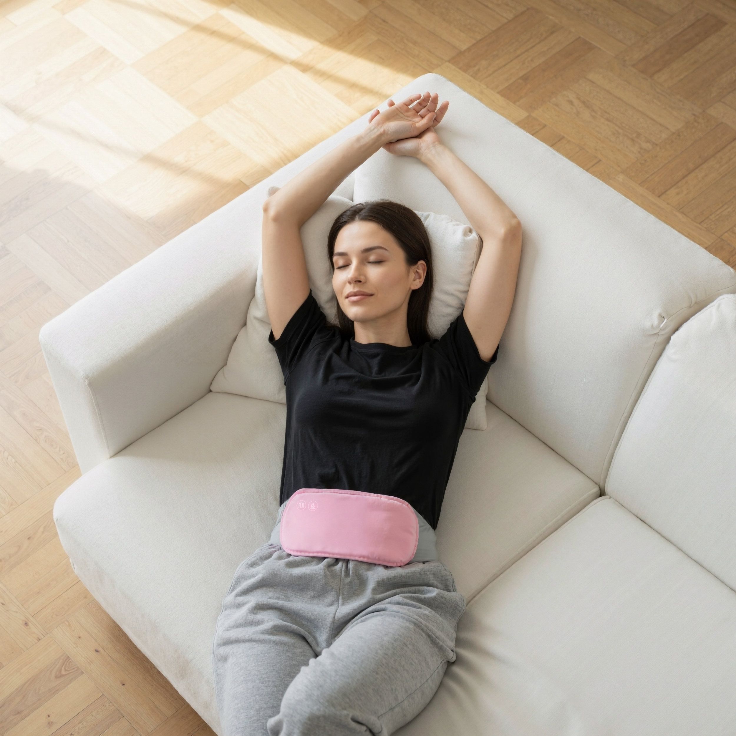 Donna sdraiata su un divano, indossa una fascia addominale rosa. La fascia è sulla pancia. Braccia sopra la testa.