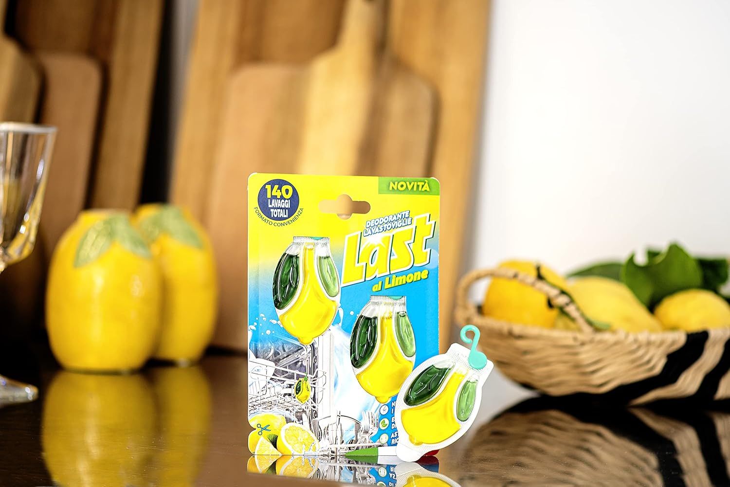 Confezione del prodotto con due deodoranti. Sulla confezione c'è scritto '140 Lavaggi Totali'. Limoni e taglieri sullo sfondo.