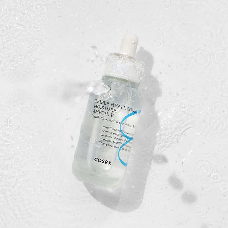 Fiala con contagocce nell'acqua. Scritta: Triple Hyaluronic Moisture Ampoule, COSRX. L'acqua schizza.