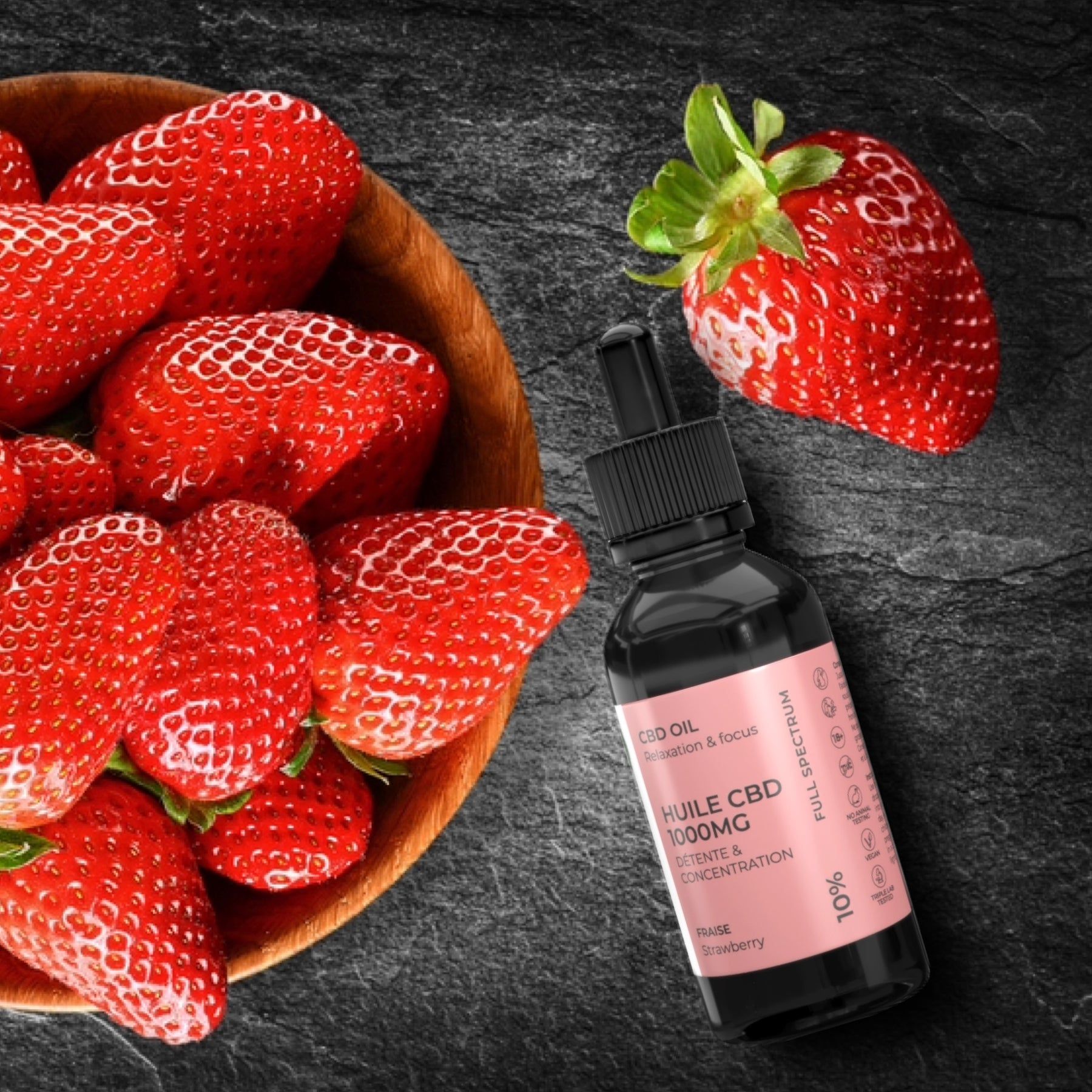 Flacone di vetro marrone con contagocce accanto a fragole in una ciotola di legno. Sfondo nero.