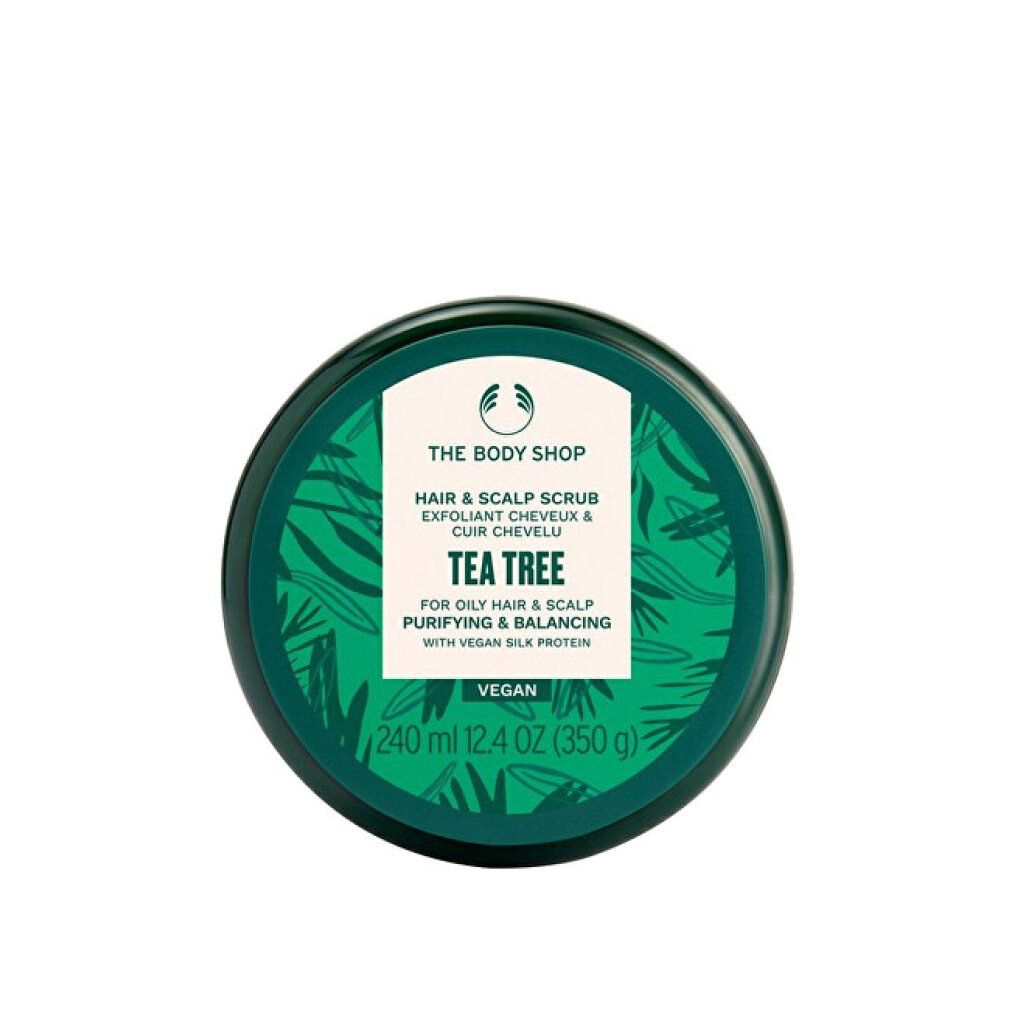Barattolo verde con etichetta bianca. Scritto: THE BODY SHOP, Hair & Scalp Scrub, Tea Tree. Vegano. 240 ml. Vista dall'alto.