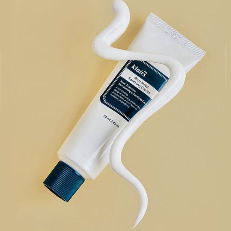 Tubo bianco con tappo blu. Scritta: klairs Rich Moist Soothing Cream. 80 ml. Filo di crema.