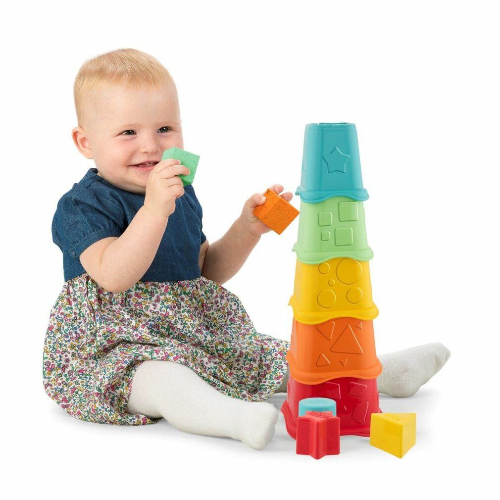 Bambino gioca con tazze impilabili. Tazze multicolore con forme geometriche. Il bambino tiene una tazza.