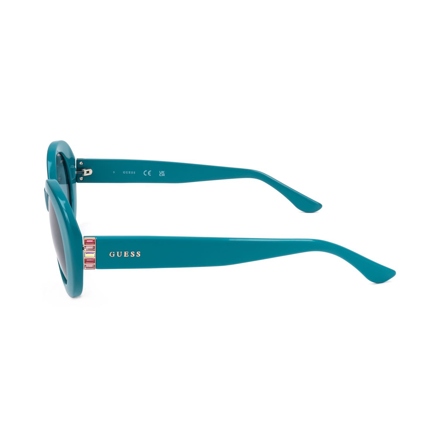 Occhiali da sole Guess turchesi con lenti ovali e logo argentato.