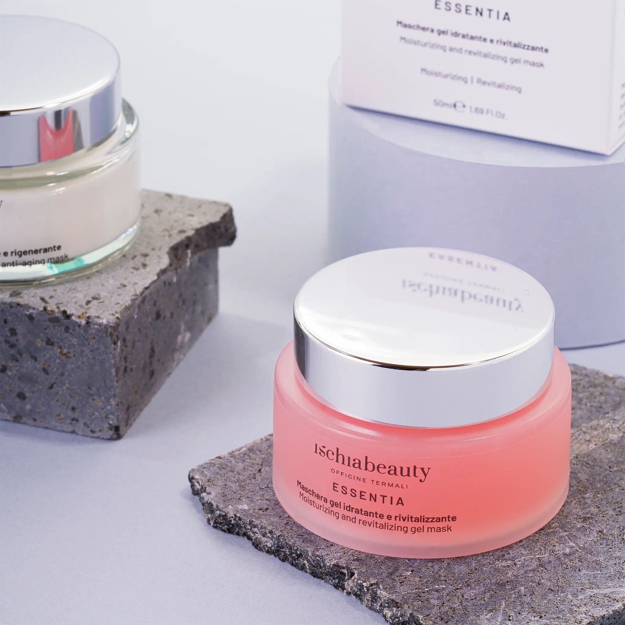 Due creme rosa in vasetti di vetro con coperchi argentati. Scritta: ischiabeauty, ESSENTIA, Maschera gel idratante e rivitalizzante.