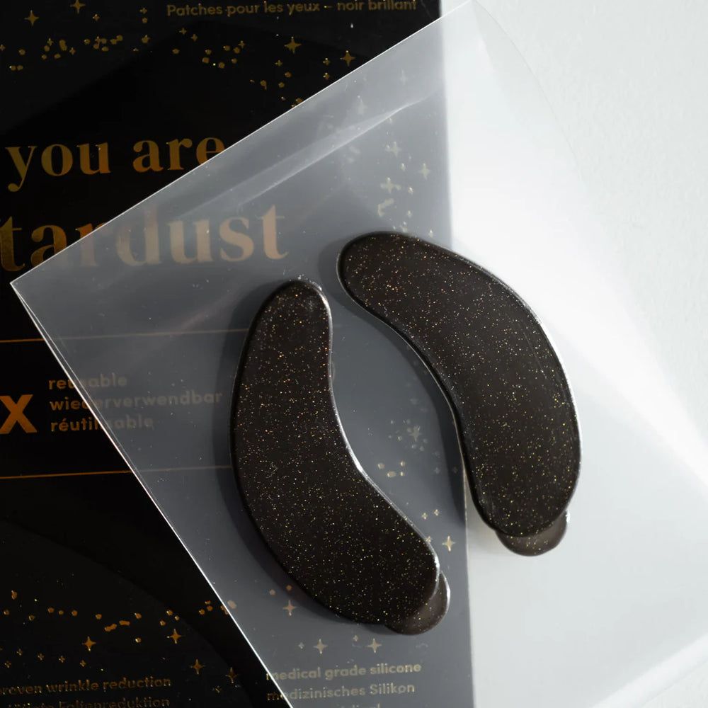 Due eye pads neri glitterati in confezione trasparente. Scritta: APRICOT, "you are stardust".