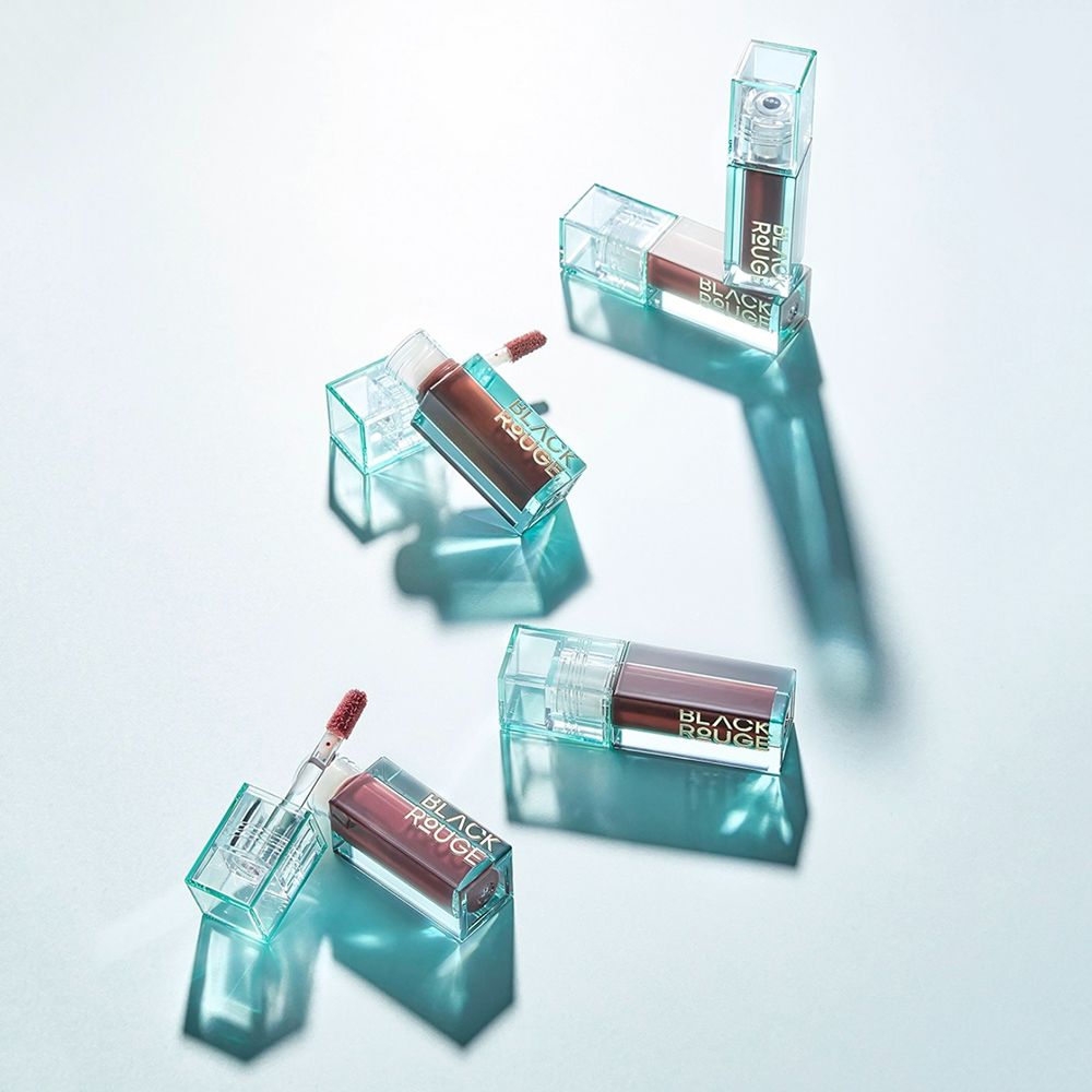 Diversi flaconi di lucidalabbra. Forma rettangolare, custodia trasparente, contenuto rosso. Scritta dorata BLACK ROUGE. Tappo menta.