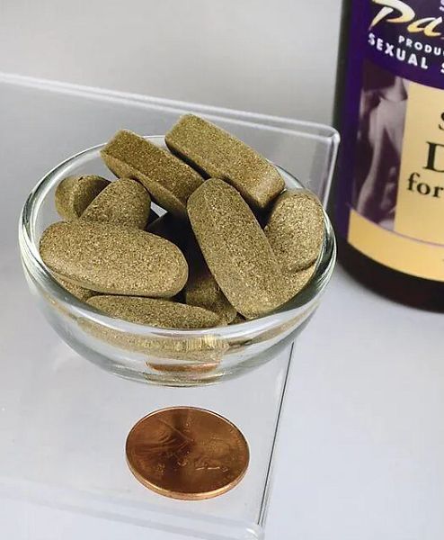 Compresse marroni in una ciotola di vetro. Accanto, una moneta e un flacone etichettato.