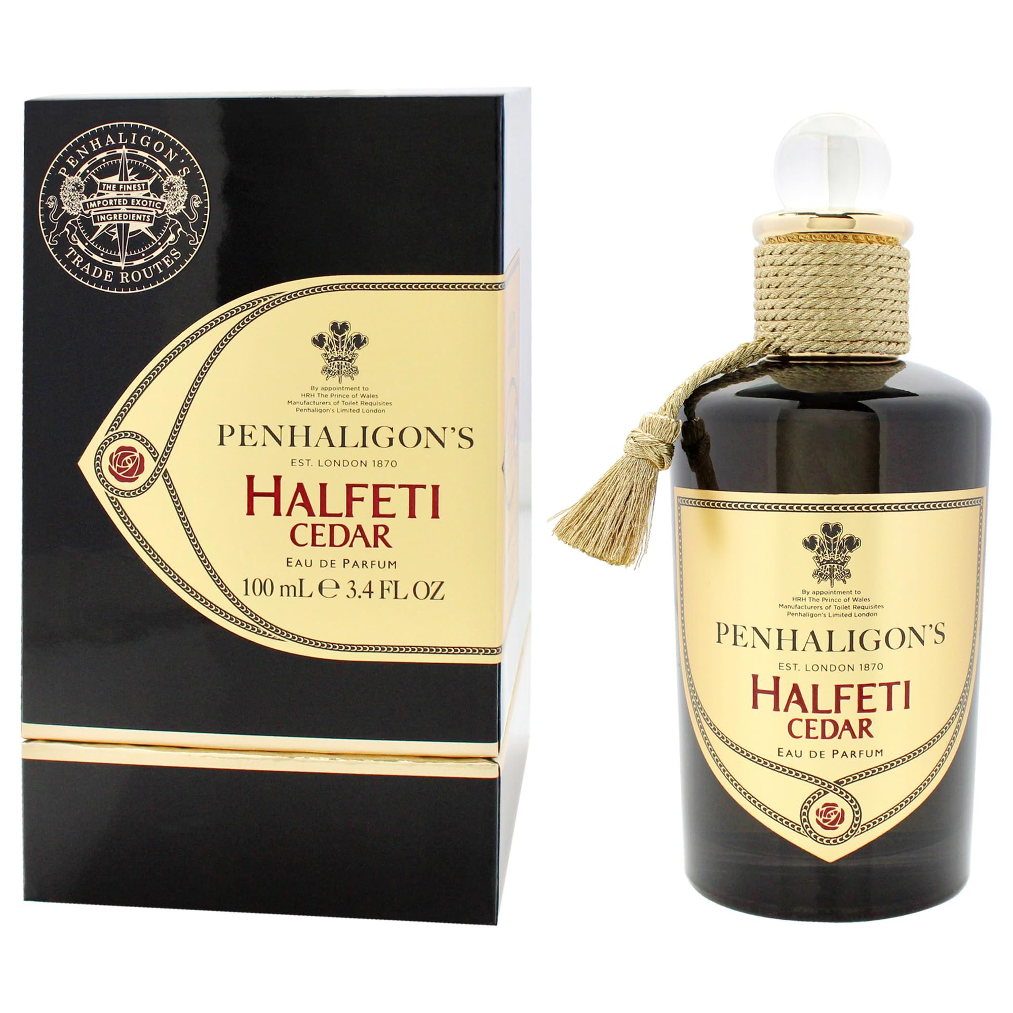 Flacone di profumo e confezione. Flacone con nappa e corda. Confezione nera con dettagli dorati e testo.