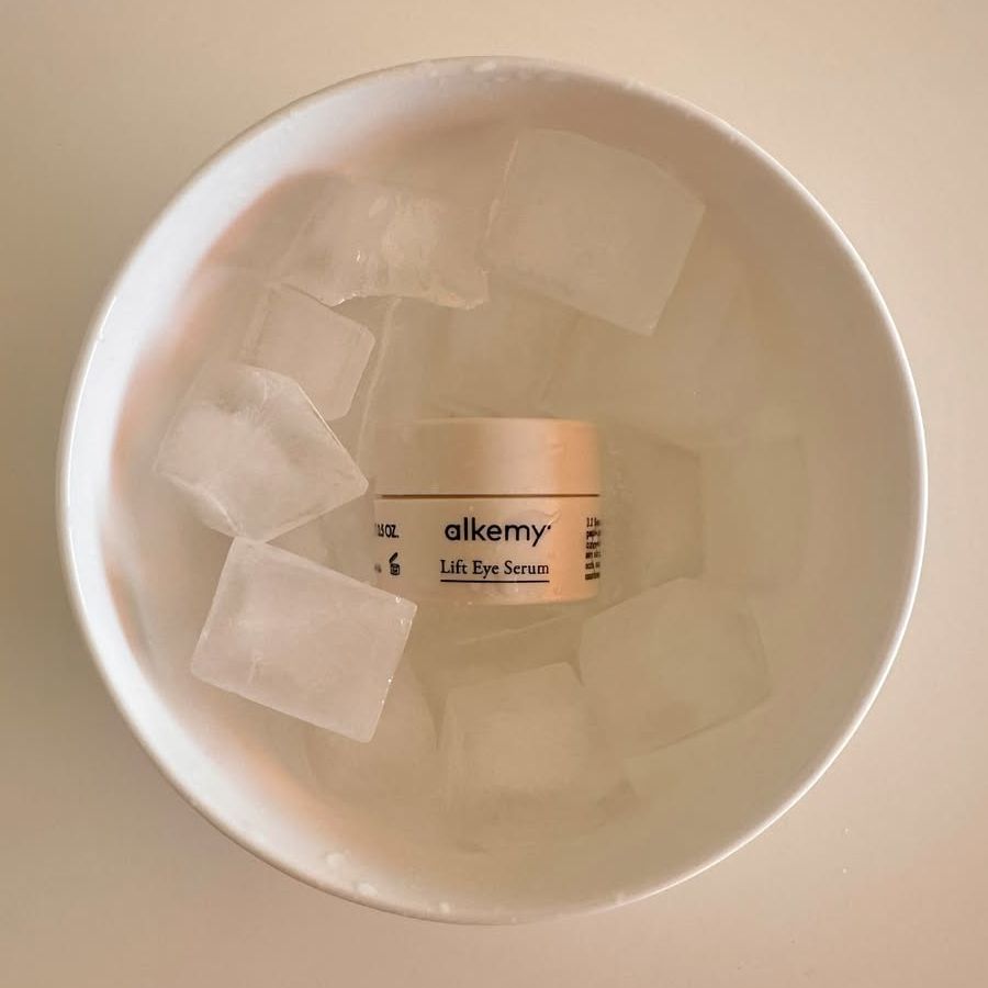 Vasetto Alkemy Lift Eye Serum in una ciotola con cubetti di ghiaccio.