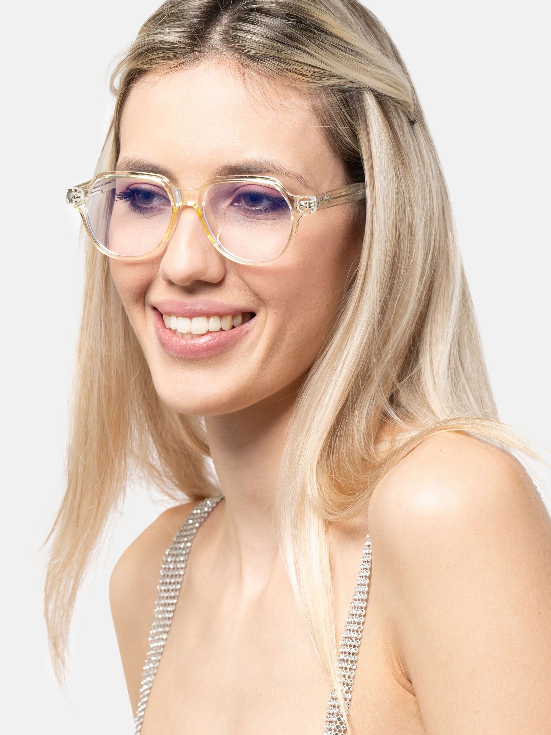 Donna con occhiali trasparenti e dettagli gialli. Sorride.