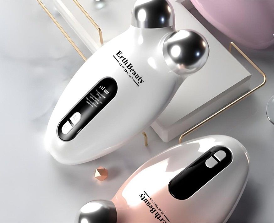 Due dispositivi per lifting facciale bianchi con sfere argentate. Scritta: "Erth Beauty Electrical".