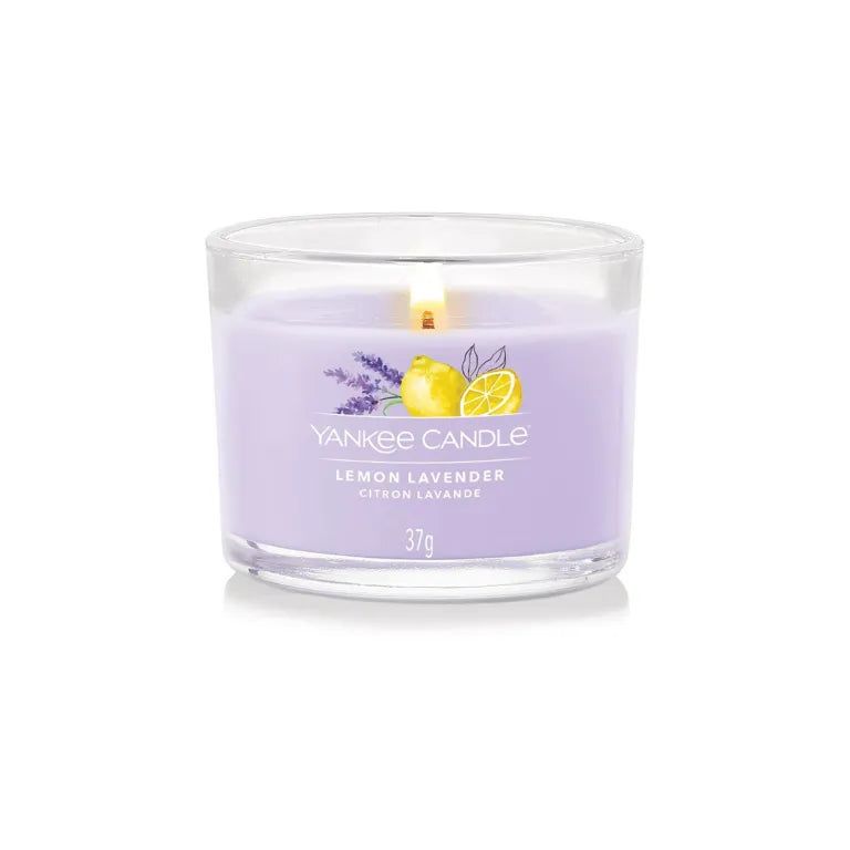 Candela profumata in vetro. Cera lilla con stampa limone e lavanda. Scritta: Lemon Lavender, Citron Lavande, 37g. Fiamma accesa.