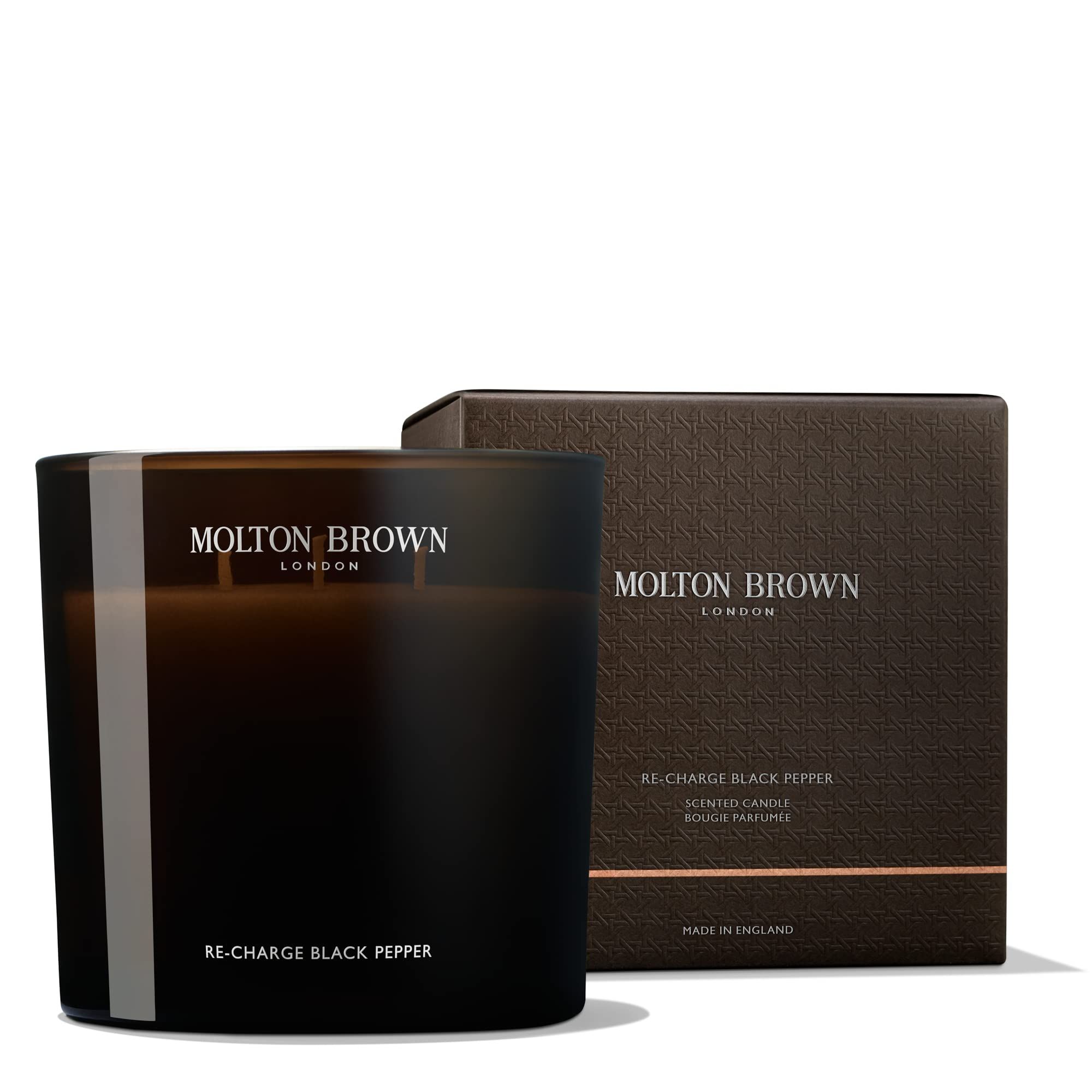 Candela nera e confezione. Scritta: Molton Brown London, Re-Charge Black Pepper. Made in England.