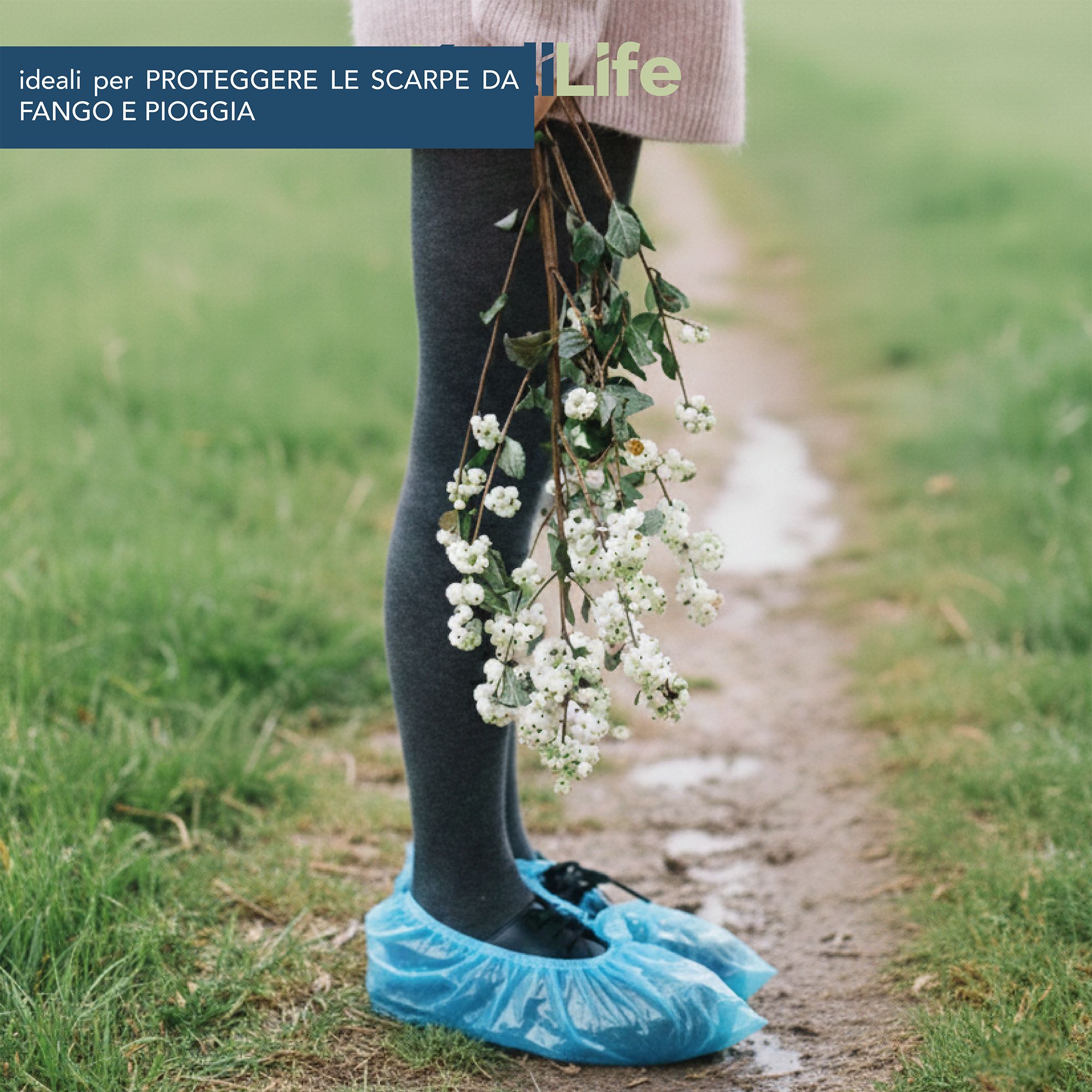 Persona con copriscarpe blu e mazzo di fiori su un sentiero di campagna.