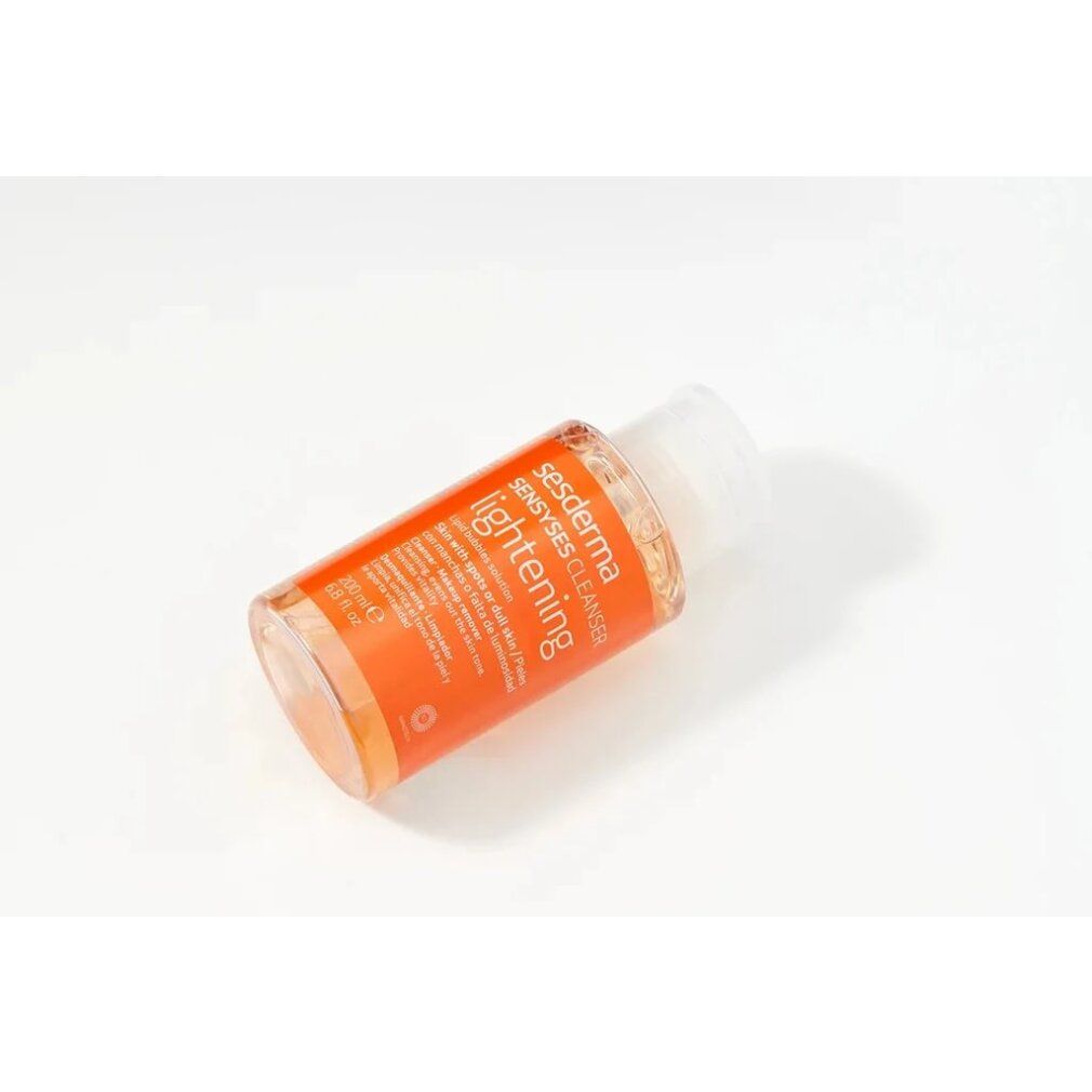Flacone trasparente con liquido arancione. Scritta: Sesderma Sensyses Cleanser Lightening. 200ml.