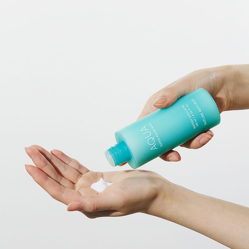 Mani che tengono una bottiglia turchese. Il prodotto viene versato nel palmo. Emulsione bianca.