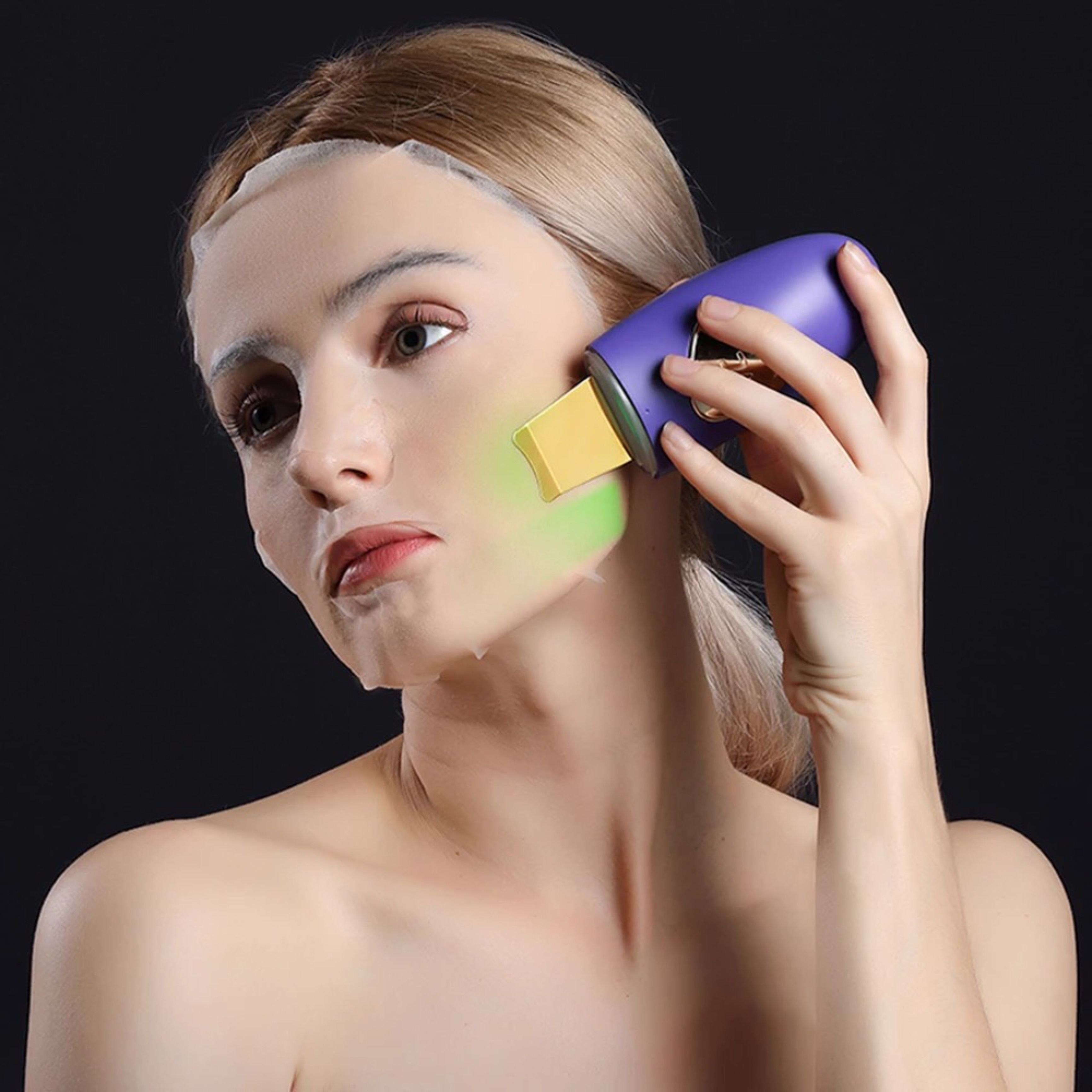 Persona con maschera facciale che utilizza il dispositivo di peeling a ultrasuoni. Dispositivo con spatola dorata e corpo viola.