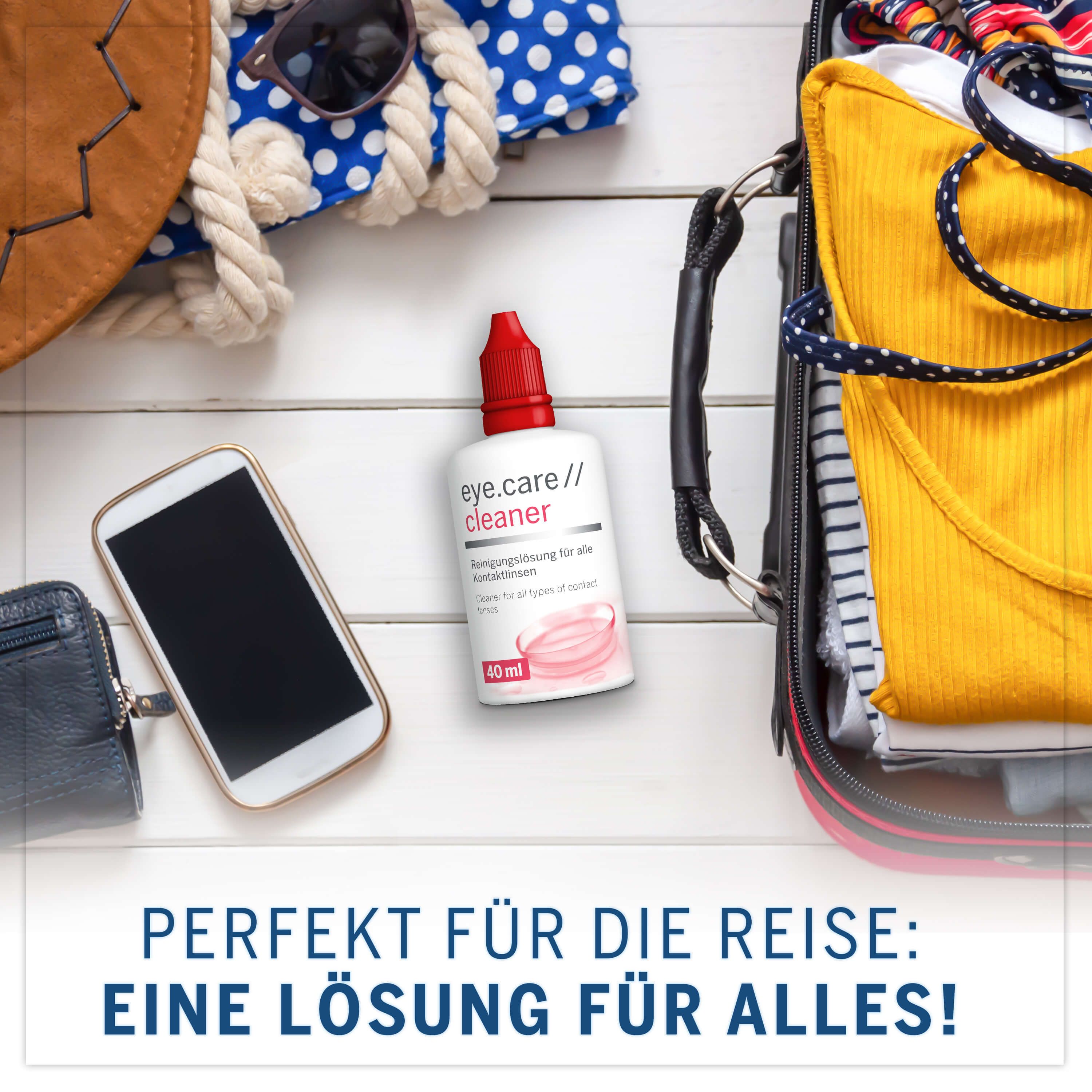 Flacone bianco con tappo rosso accanto a bagagli, telefono e accessori. Testo: eye.care // cleaner, 40 ml.