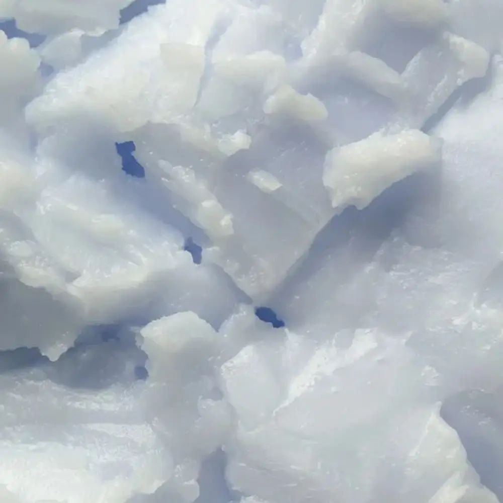 Primo piano di balsamo bianco a pezzi irregolari. Lo sfondo è azzurro.