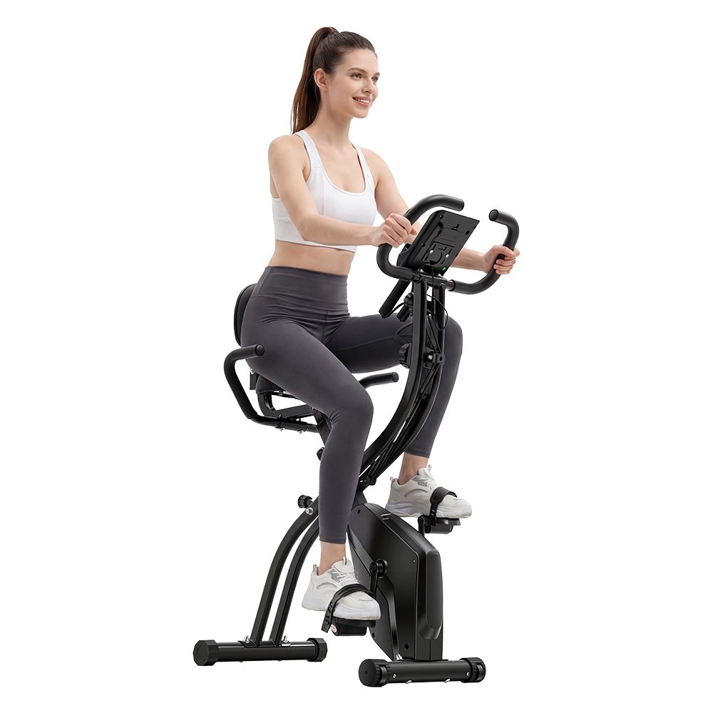 Donna su cyclette nera. Cyclette nera con sedile e manubrio.