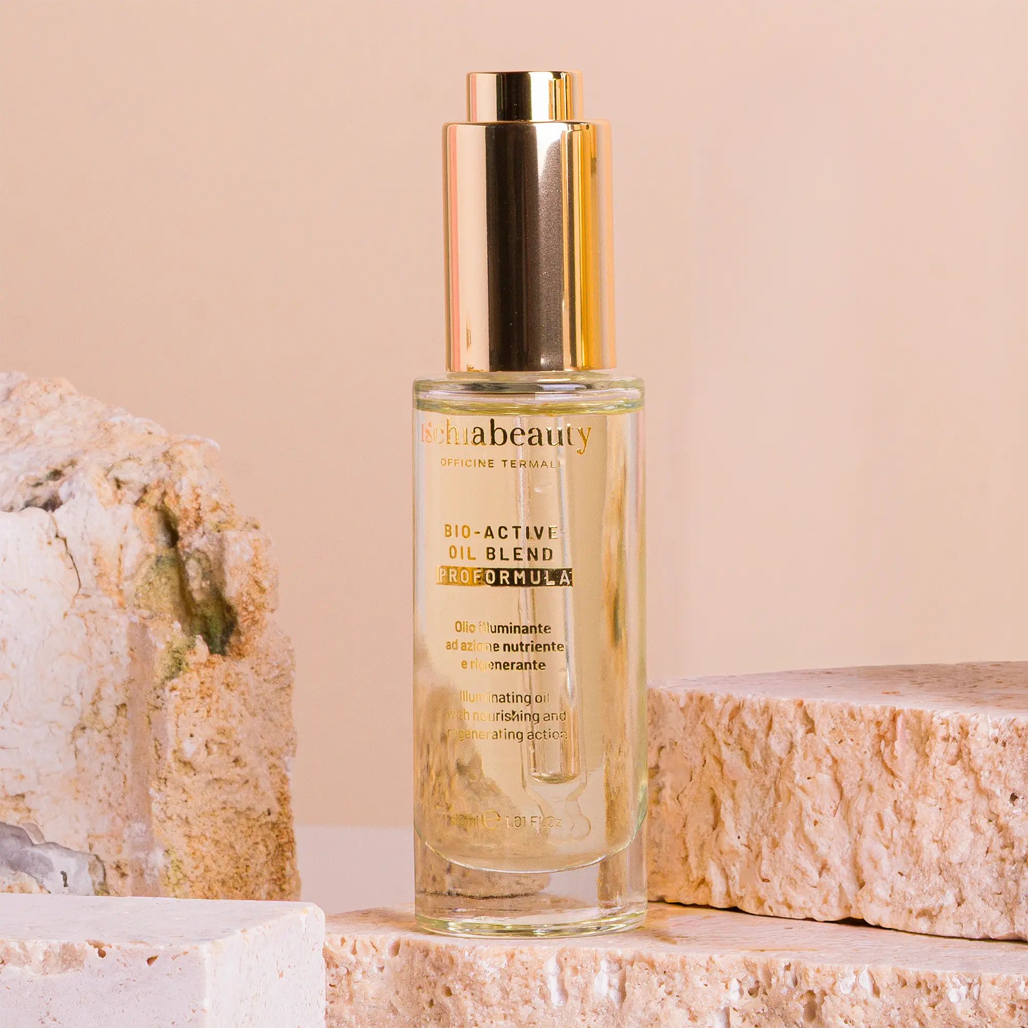 Flacone in vetro con pipetta dorata. Scritta: ischiabeauty, BIO-ACTIVI OIL BLEND. Posizionato su pietre.