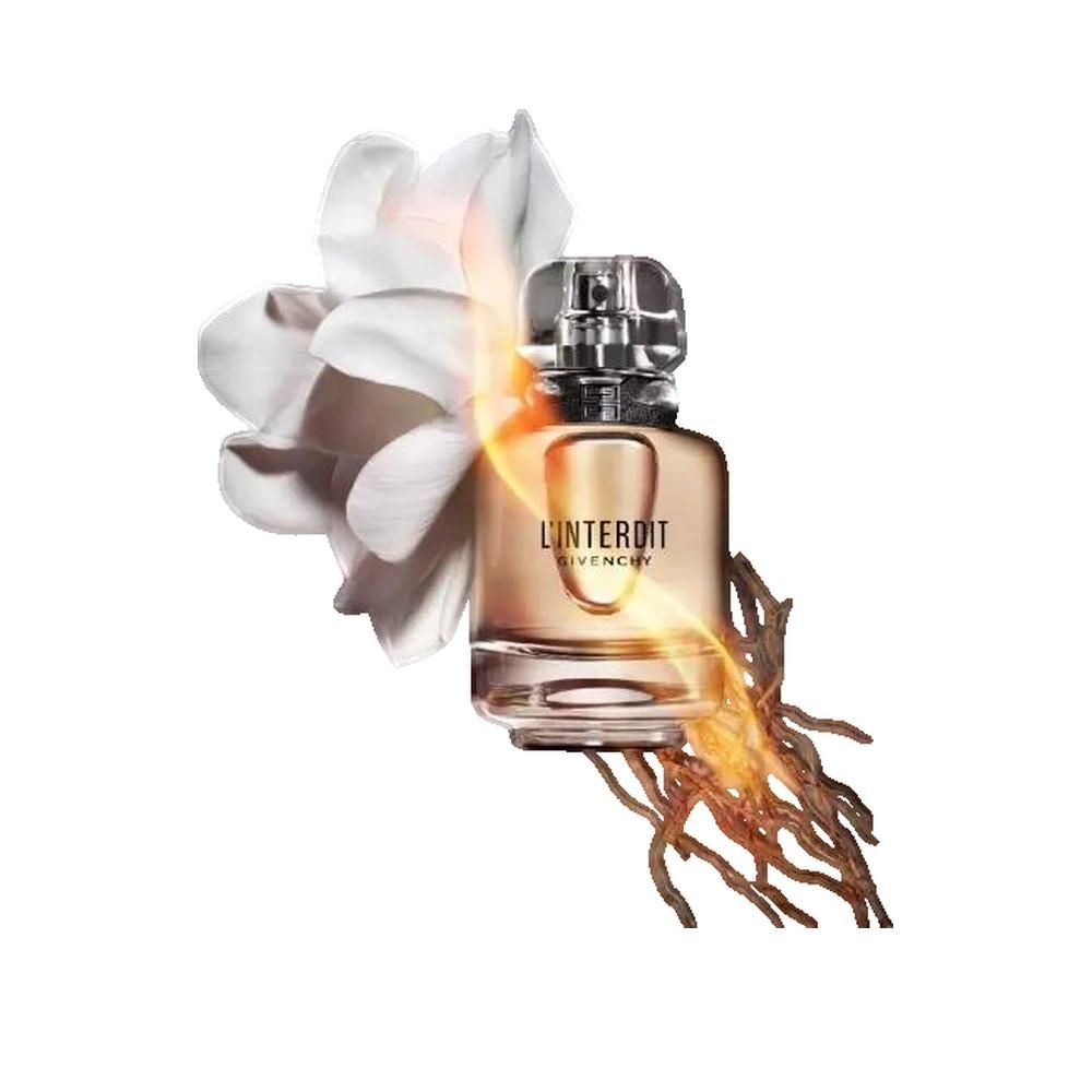 Flacone di profumo con scritta L'Interdit Givenchy. Accanto al flacone, un fiore bianco e rami marroni.