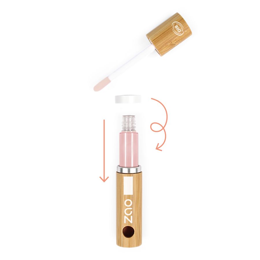 Contenitore in bambù con coperchio e applicatore aperti. Il contenitore contiene un liquido rosa. Le frecce indicano l'applicazione.