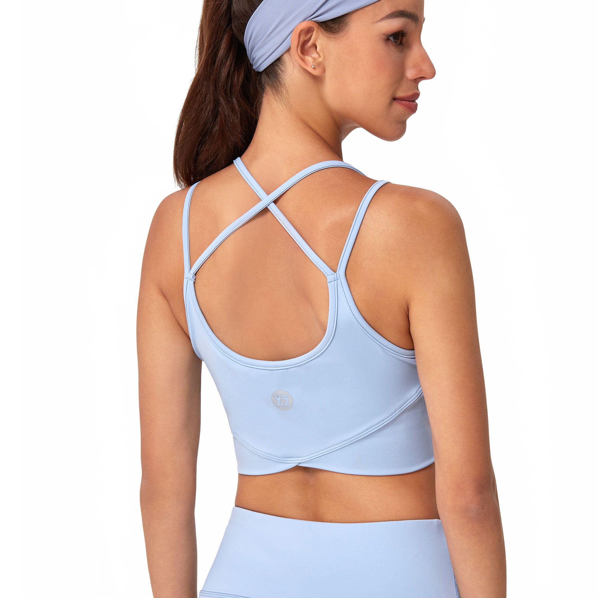 Brassiere sportiva azzurra con spalline incrociate sulla schiena e logo discreto.