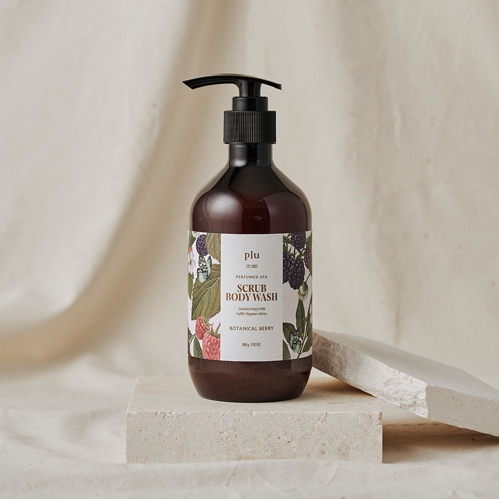 Flacone marrone con dosatore nero. Etichetta con nome del prodotto e illustrazioni floreali. Posizionato su un piedistallo.