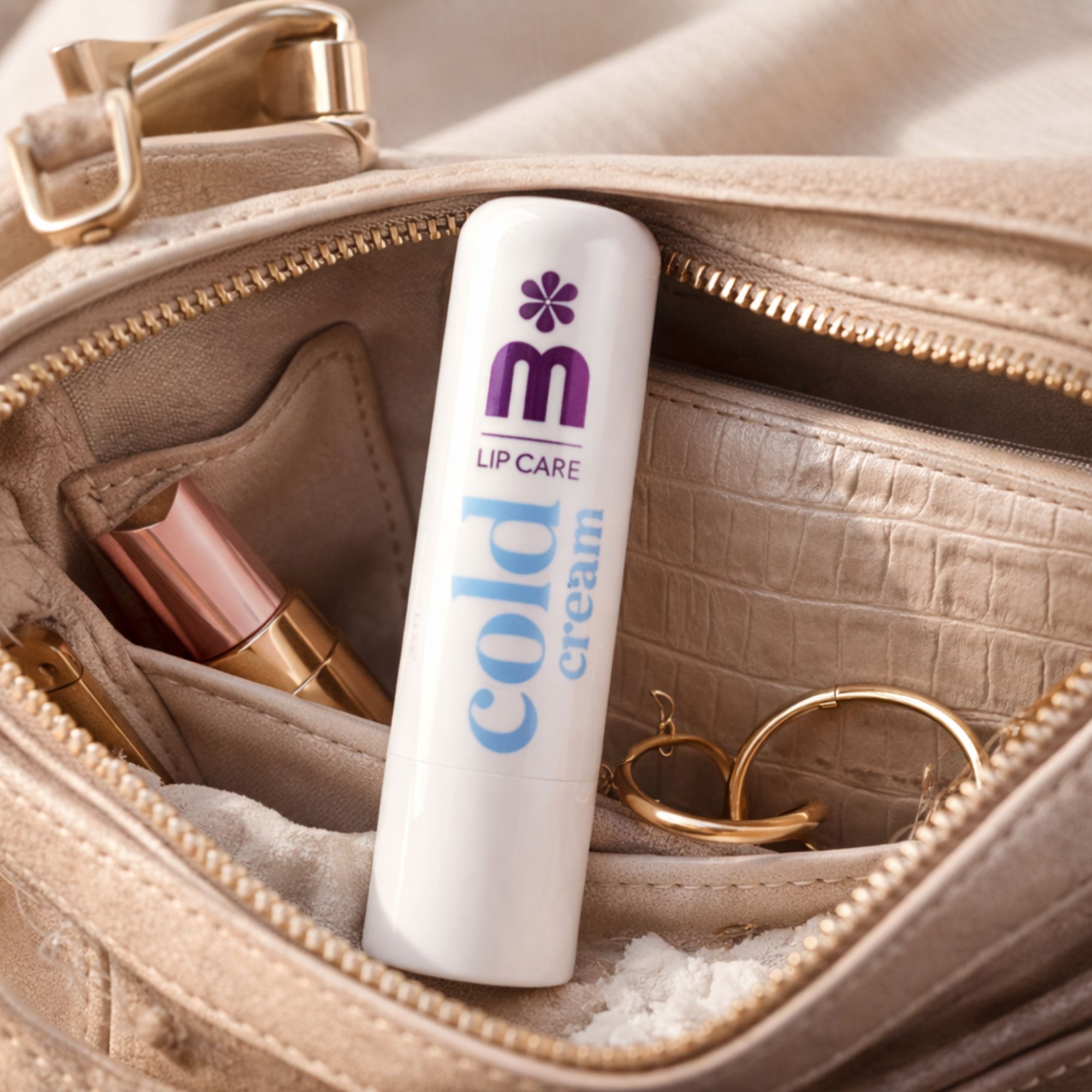 Stick di balsamo labbra bianco in una borsa chiara, accanto a rossetto e gioielli.